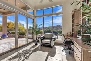 Sunroom featuring a mountain view, built in desk, tile patterned flooring, and floor to ceiling windows