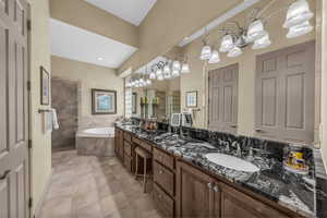 Full bathroom featuring double vanity, a walk in shower, a garden tub, and light tile patterned floors