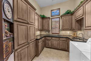 Laundry area featuring cabinet space, light tile patterned floors, and washer and clothes dryer