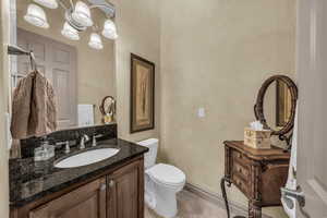 Half bath featuring vanity, light tile patterned flooring, and a chandelier