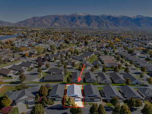 Aerial perspective of suburban area featuring property boundaries highlighted and a mountainous background