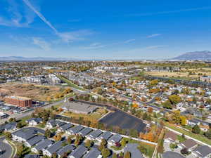 Aerial view of property and surrounding area with a mountain backdrop and nearby suburban area