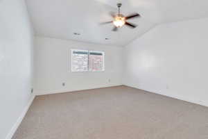 Spare room with light carpet, lofted ceiling, and ceiling fan