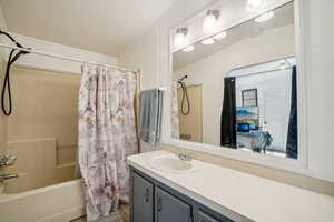 Bathroom with shower / tub combo with curtain, vanity, and ensuite bathroom