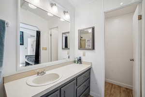 Bathroom featuring vanity, light wood finished floors, and ensuite bath