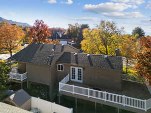 Rear view of property featuring a chimney and a wooden deck