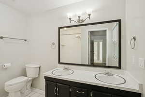 Full bath with light tile patterned floors, double vanity, and a marble finish shower