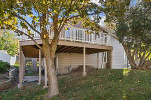 Back of house featuring a wooden deck and a yard