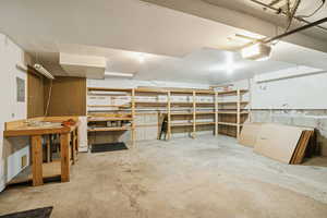 Garage with a garage door opener, electric panel, and a workshop area