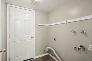 Laundry area featuring a textured ceiling and hookup for an electric dryer
