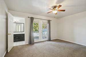 Empty room featuring french doors, light colored carpet, and ceiling fan