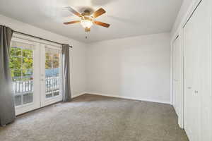 Unfurnished bedroom with french doors, light carpet, access to outside, and a ceiling fan