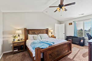 Bedroom featuring carpet flooring, vaulted ceiling, a ceiling fan, and a textured ceiling