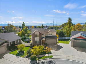 View of front of home with a garage, a mountain view, driveway, and a residential view