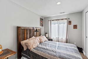 Carpeted bedroom featuring a textured ceiling