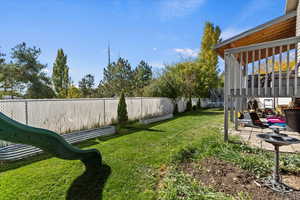 Fenced backyard with a trampoline and a patio area