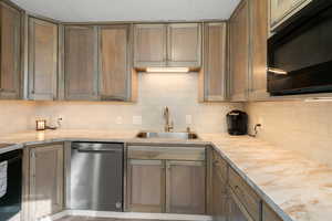 Kitchen with black appliances, light countertops, and tasteful backsplash