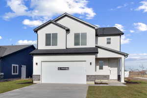 View of front facade with stucco siding, a garage, concrete driveway, and roof with shingles