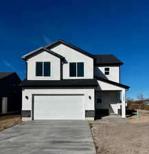 View of front of home featuring an attached garage, stucco siding, concrete driveway, and a shingled roof