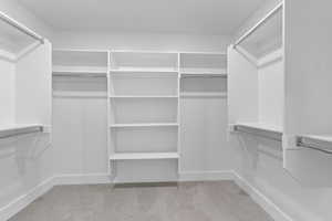 Walk in closet with light colored carpet