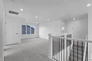 Hall with carpet floors, recessed lighting, and an upstairs landing