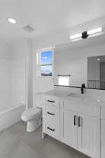 Full bath with vanity, light tile patterned floors, and bathing tub / shower combination