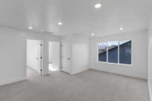 Unfurnished bedroom featuring light carpet and recessed lighting