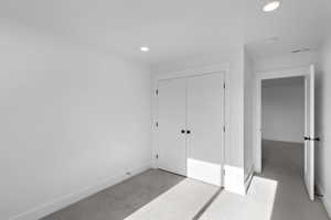 Unfurnished bedroom featuring carpet, a closet, and recessed lighting