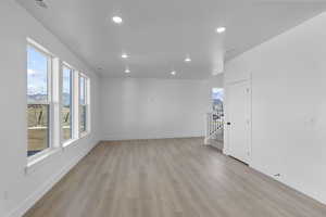 Spare room with light wood-style flooring, stairs, and recessed lighting