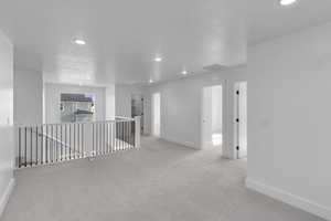 Spare room featuring recessed lighting, light colored carpet, and attic access