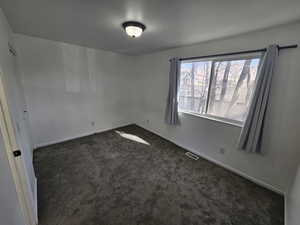 Room featuring dark carpet and baseboards