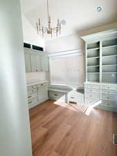 Mudroom featuring light wood-type flooring, a chandelier, and vaulted ceiling