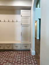 Mudroom featuring brick flooring and arched walkways
