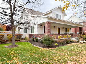 View of property exterior with brick siding, covered porch, and board and batten siding