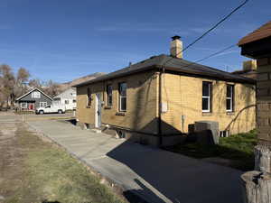 View of home's exterior with brick siding and a chimney
