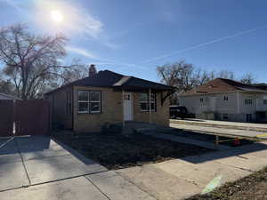 Bungalow-style house featuring brick siding and a chimney