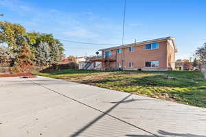 Rear view of property featuring a wooden deck, stairway, and brick siding