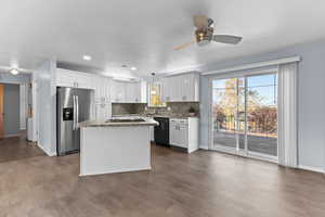 Kitchen featuring stainless steel fridge with ice dispenser, a center island, tasteful backsplash, white cabinets, and pendant lighting