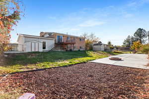Rear view of house with a shed, stairway, a deck, and an outdoor fire pit