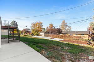 View of yard featuring a patio, stairway, and a fire pit