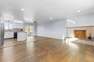 Unfurnished living room featuring ceiling fan, dark wood-style flooring, recessed lighting, and a textured ceiling