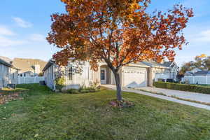 View of property hidden behind natural elements with concrete driveway and a garage