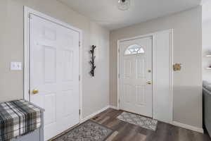 Entryway with baseboards and dark wood finished floors