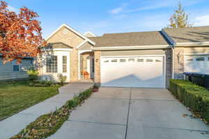 Single story home with brick siding, concrete driveway, roof with shingles, a front lawn, and a garage