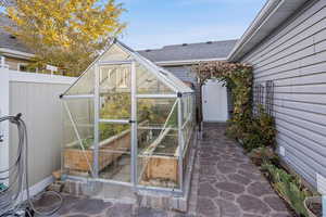 View of patio / terrace featuring a greenhouse and an outbuilding