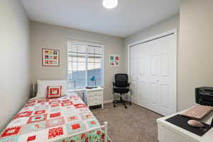 Bedroom featuring light carpet and a closet