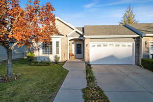 Ranch-style house featuring brick siding, a shingled roof, driveway, and a front yard