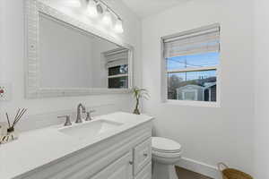 Half bathroom featuring vanity and toilet