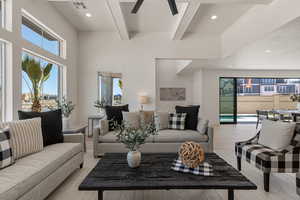 Living area featuring beam ceiling, light wood finished floors, ceiling fan, recessed lighting, and a towering ceiling
