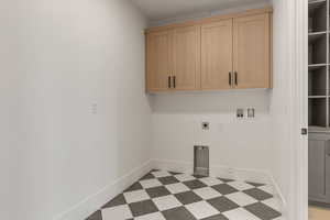 Washroom with light floors, hookup for an electric dryer, washer hookup, and cabinet space